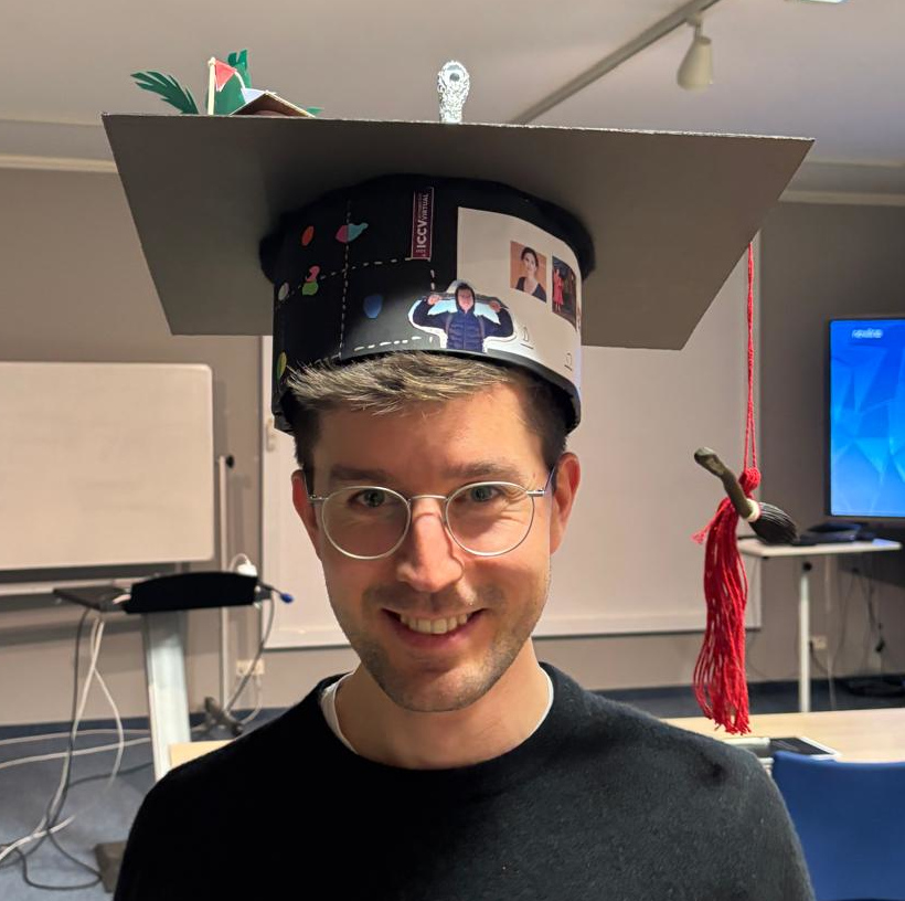 Lorenz Rumberger wearing his doctoral cap inside a seminar room